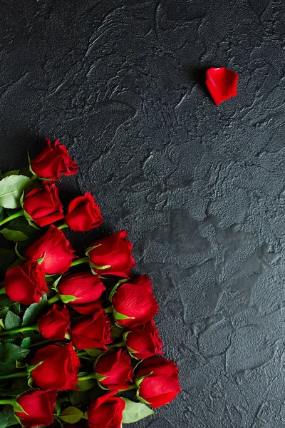 Red roses on a black textured background. Place for text, top vi — Stock Photo, Image