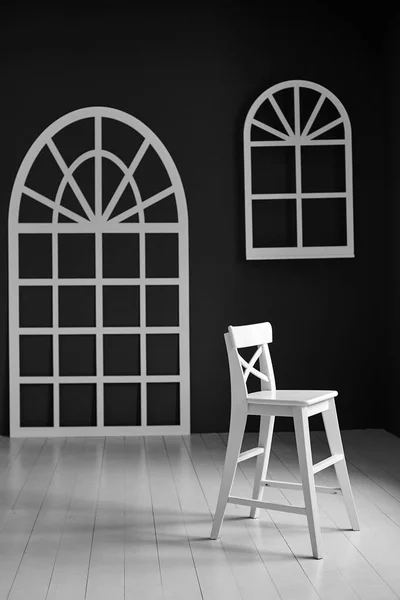 Bílá židle na tmavém pozadí. Stěna je detailně ozdobena — Stock fotografie