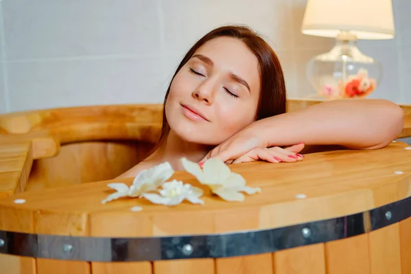 Donna con trattamento spa e relax nella sauna a botte calda in legno, nella vasca da bagno in cedro — Foto Stock