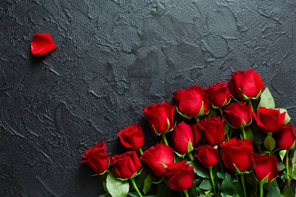 Red roses on a black textured background. Place for text, top view — Stock Photo, Image