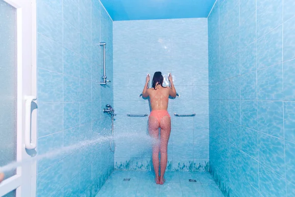 Giovane donna in costume da bagno con massaggio ad alta pressione con doccia Charcot. Trattamento anticellulite nel salone SPA — Foto Stock