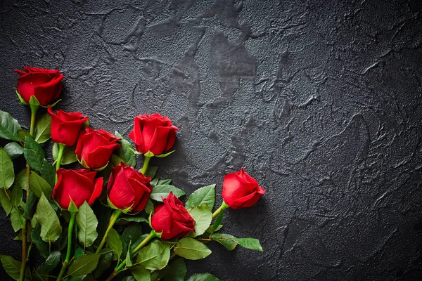 Rudé růže na černém, texturovém, kamenném pozadí. Místo pro text, pohled shora — Stock fotografie