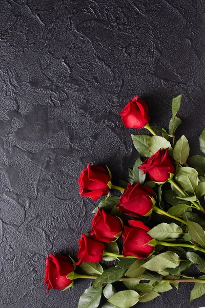Czerwone róże na czarnym, teksturowanym, kamiennym tle. Miejsce na tekst, widok z góry — Zdjęcie stockowe