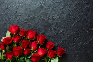 Siyah dokulu arka plan üzerinde kırmızı güller. Metin için yer, üst vi