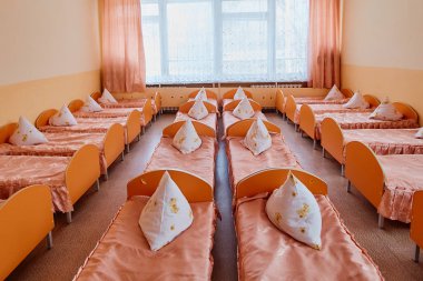 Cots in the kindergarten. Orphanage or boarding school. Beds in a boarding school or in an orphanage clipart