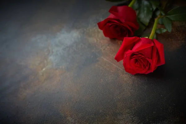 Червоні троянди лежать на текстурованому плямистому мармуровому фоні. Знак співчуття, співчуття до втрати. Пробіл для вашого тексту . — стокове фото