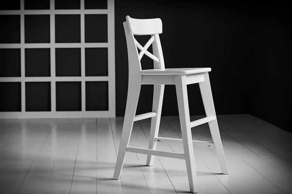 Bílá židle na tmavém pozadí. Stěna je detailně ozdobena — Stock fotografie