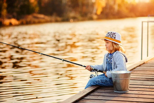 Eenzaam klein kind vissen vanaf houten dock op lake. — Stockfoto