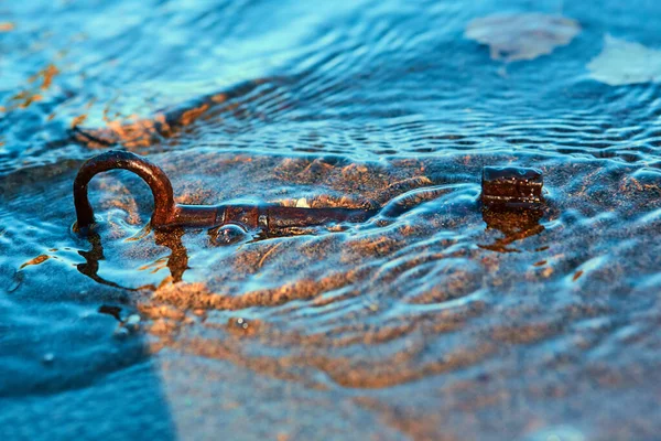 La vieille clé vintage en fer lavé à terre en vagues. Qui le trouvera le premier et il deviendra riche et heureux — Photo