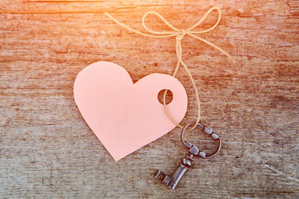 Corazón y llave antigua en el fondo de madera natural antigua. En blanco para una postal con su texto. La vista desde arriba — Foto de Stock