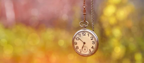 Vintage-Uhr an einer Kette auf abstraktem Hintergrund — Stockfoto