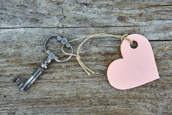 Una llave hecha a mano antigua con un llavero de etiqueta en forma de corazón se encuentra — Foto de Stock