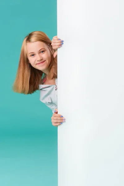 Smiling Girl Stands White Blank Panel Isolated Turquoise Background Looks — Stock Photo, Image