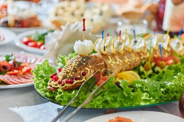 Oval bir tabakta Rus ulusal mutfağı doldurulmuş turna balığı pişmiş balık, otlarla, limonlarla, kızılcıklarla süslenmiş..