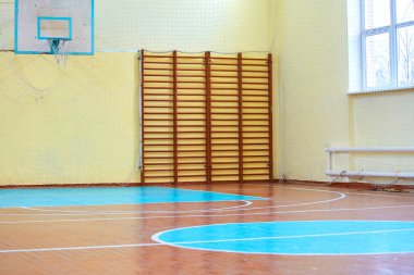 Okuldaki ya da üniversitedeki spor dersleri için spor salonu. İsveç duvarı, merdivenler ve voleybol için işaretli ahşap zemin.