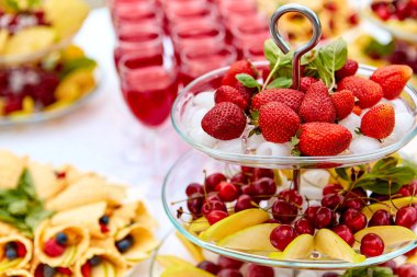 Çilekli, çilekli yakın çekim tabağı. Ahududu, kiraz, yaban mersini ve fırında pişmiş yiyecekler. Festivaldeki büfe masası. Yemek konsepti