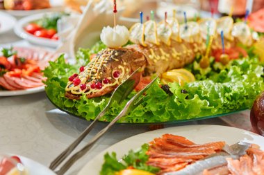 Oval bir tabakta Rus ulusal mutfağı doldurulmuş turna balığı pişmiş balık, otlarla, limonlarla, kızılcıklarla süslenmiş..