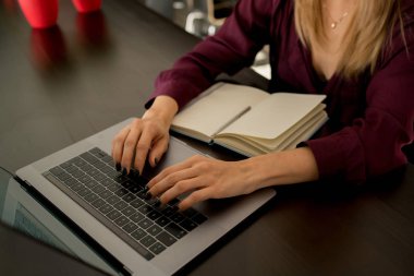 Dizüstü bilgisayarda yazarak yakın çekim. Kahve barı, masada oturan genç iş kadını senin defter ekrana bak ve iş stratejisi düşünmek. Not defterinizdeki kız almak. Tablo laptop ve defter.