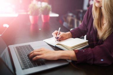 Defter kalem defter kahve dükkanında kullanarak yazma el. Modern netbook bilgisayar kullanarak bir defterde Not yazmak için kablosuz bağlıyken Internet online arama talebi.