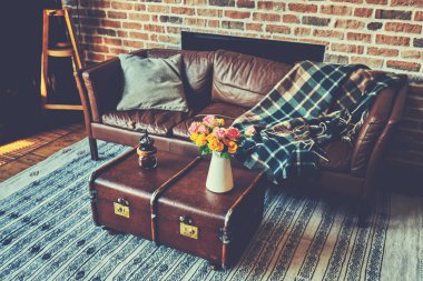 Natürmort iç ayrıntılar, çiçek, vazo kanepe yastık ve sıcak bir battaniye ile yakınındaki vintage sehpa.