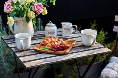 Lezzetli kahvaltı kahve otelin balkon, taze kruvasanlar ve jamon bir ahşap masa vintage üzerinde dilim ile.