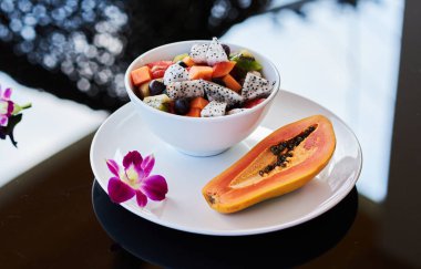 Siyah bir masada güzel dilimlenmiş meyve tabağı.