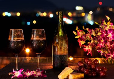 İki bardak ve şişe şarap gece şehir arka plan üzerinde.