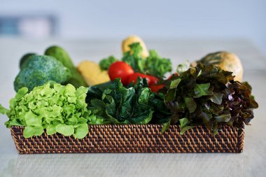 Taze ve olgun sebze mutfak masasının üzerinde bir sepet içinde tanzimi. Seçici odak.