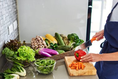 Genç kadın mutfak sağlıklı yemek pişirme sebze salatası. Elinde bir bıçak ve bir kesme tahtası üzerinde sebze kesme. Evde yemek sağlıklı yaşam tarzı.