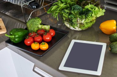 Sağlıklı beslenme, diyet, kalori sayma ve kilo kaybı kavramı. Tablet pc ve sebze masada.