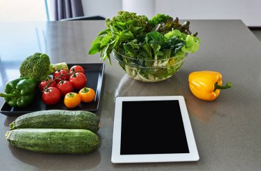 Yemek tarifleri mutfak masasının üstünde bilgisayar tablet.