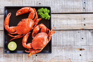 Buharda pişmiş yengeç ve eski ahşap zemin üzerine taze limon. Deniz gıda yemek kavramı.