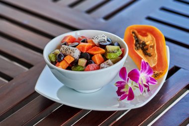 Diyet gıda - taze çiğ tropikal meyve bir sürü içerir papaya, portakal, kivi beyaz bir kase içinde.