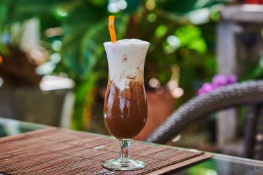 Buzlu kahve ile ahşap masa çırpılmış krem karamel.