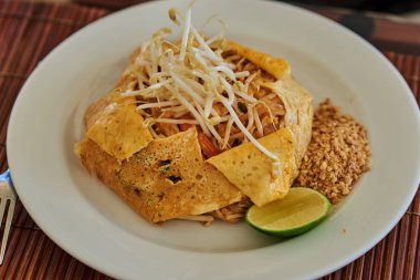 Tay uzmanlık karıştırın kızarmış pirinç noodle ile kızarmış tofu ve omlet ile hizmet veren karides şal, yeni bıçak, ezilmiş ızgara fıstık, kireç ve fasulye filizi.