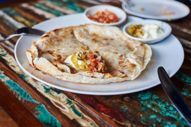 Ev yapımı quesadilla tavuk, el yapımı salsa ve yoğurt vintage ahşap tablo.
