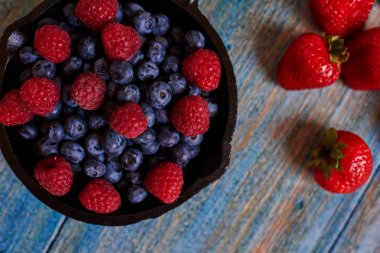 Yukarıdan bir ahşap yüzey güzel taze bir dökme demir tava çilek, tatlı kokteyl için görünümdür
