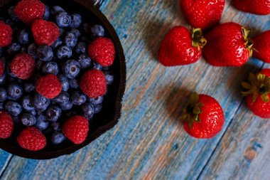 Taze yaban mersini ve büyük Olgun çilek olan yakın çekim, dökme demir tencere