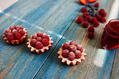 İştah açıcı lezzetli tart masada, ev yapımı reçel, ev hanımı bulaşmış reçel tart ve taze ahududu ile dekore edilmiş üst yanında duran vardır