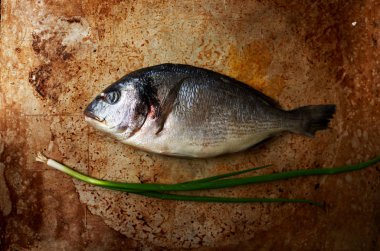 Taze levrek pişirme için bir fırın tepsisine yalan ile aromalı