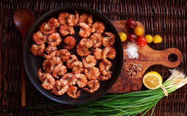 Soya sosuna bir dökme demir tavada servis zeytinyağı ilk basında sarımsaklı Kızarmış karides limon suyu dökülür, Sarı kiraz domates ve kırmızı soğan karides ile kompozisyon tamamlayıcı