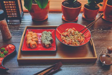 Bu bir ahşap bir remake iki kırmızı tabak karides ve Suşi Japon noodles ile geçerli. Yemek suşi ofiste ve Japon sipariş erişte pirinç