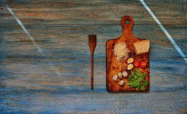 Bir ahşap eski püskü retro bir ahşap tahta kesme sebze üzerine Parmesan peyniri, bıldırcın yumurtası ve kiraz domates, büyük ahşap çatal yakınındaki bir parçasıdır geçerli