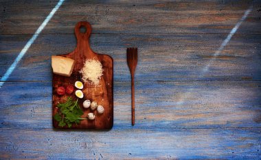 Üstten görünüm işyerinde aşçı lüks İtalyan restoranı, ahşap kesme tahtası üzerinde yalan Parmesan peyniri salatası, bıldırcın yumurtası, taze domates için malzemeler