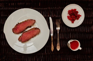 İki aşçılar hızlı bir şekilde bir tavada, sos domates ve sıcak biber yapılmış yüksek ateşte ızgara pirzola domuz eti bonfile hazırlamak