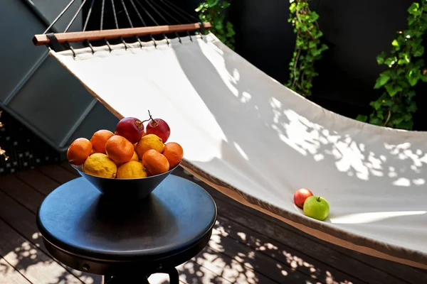 Beautiful home patio with a hammock and fruit on the table.