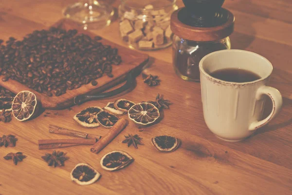 Dry orange and lemon, coffee beans and cinnamon on wooden brown background.