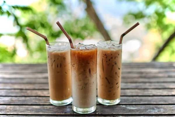 ホイップ ミルクと素朴な木製のテーブル 選択と集中の背の高いグラスにキャラメル アイス コーヒー — ストック写真