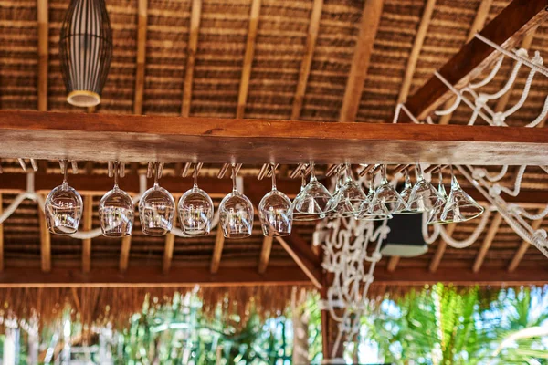 Glasses hanging over bar rack. Empty glasses for wine above a bar rack.