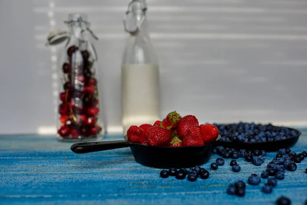 Auf Einem Blauen Holztisch Stehen Zwei Gusseiserne Pfannen Mit Erdbeeren — Stockfoto